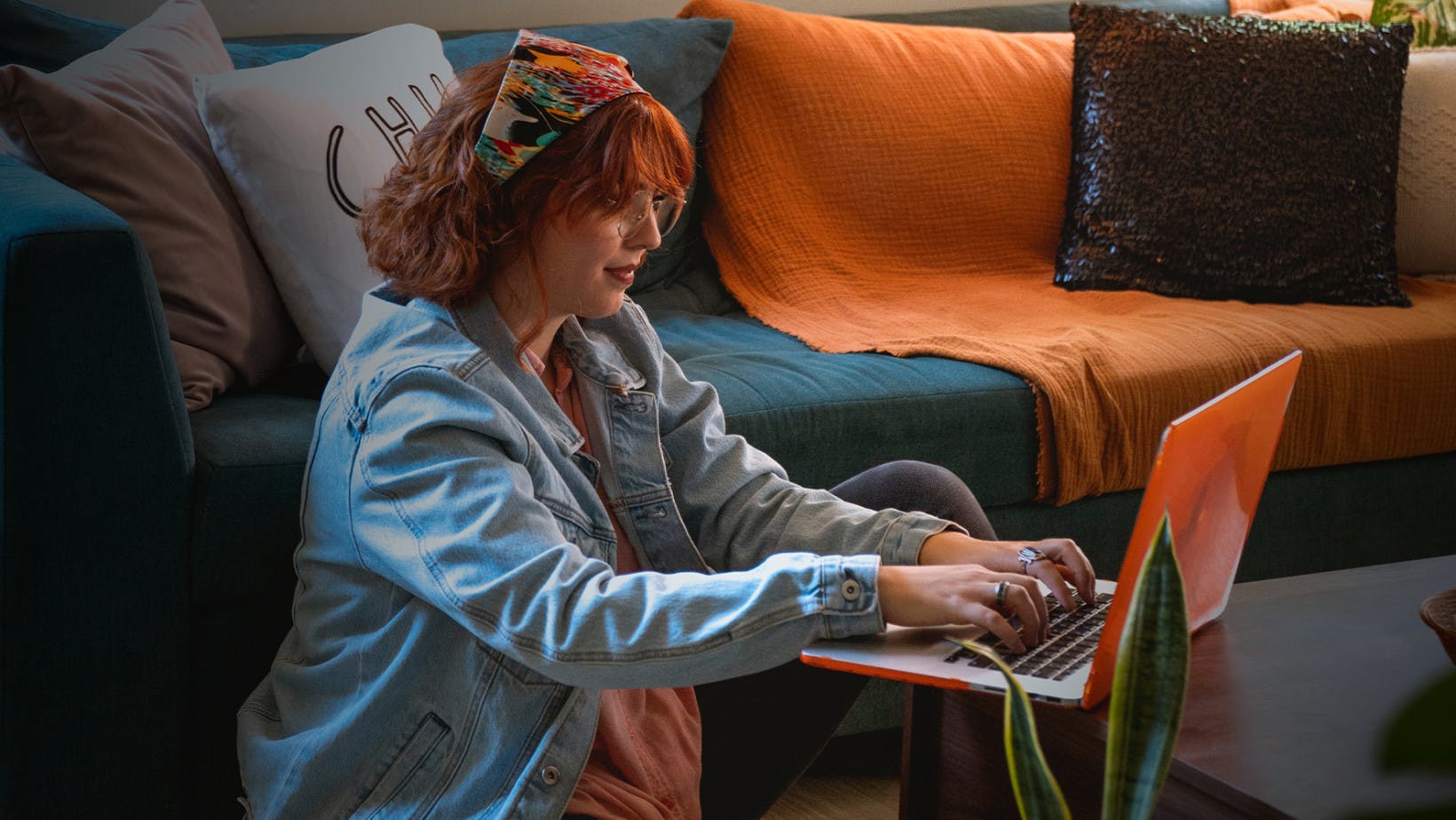 Redhead woman doing college work on her laptop in a living room