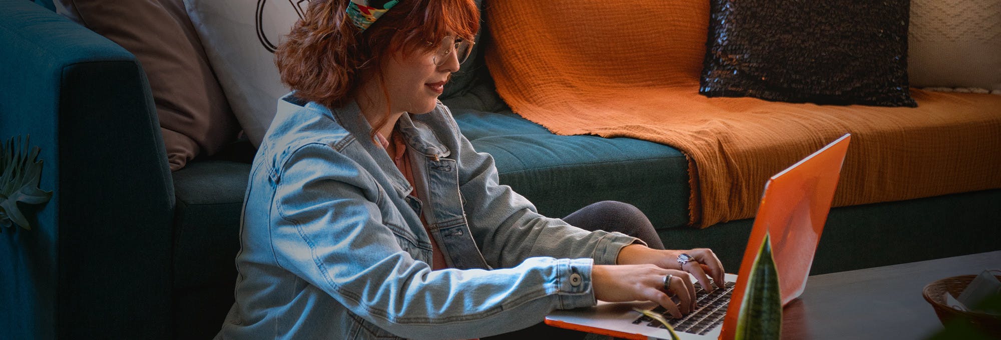 Redhead woman doing college work on her laptop in a living room