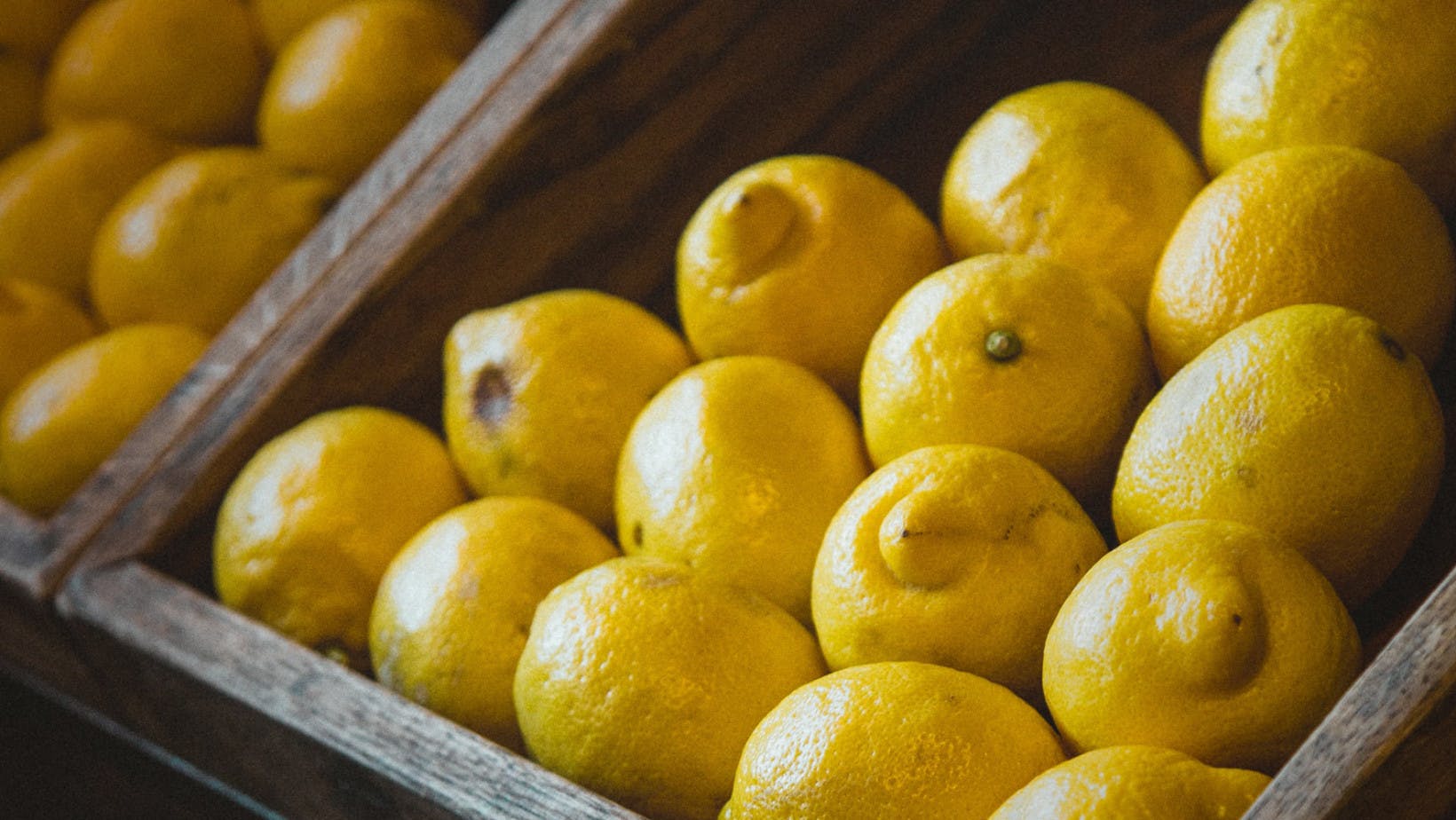 Lemons on a wooden market shelf representing quantity demanded