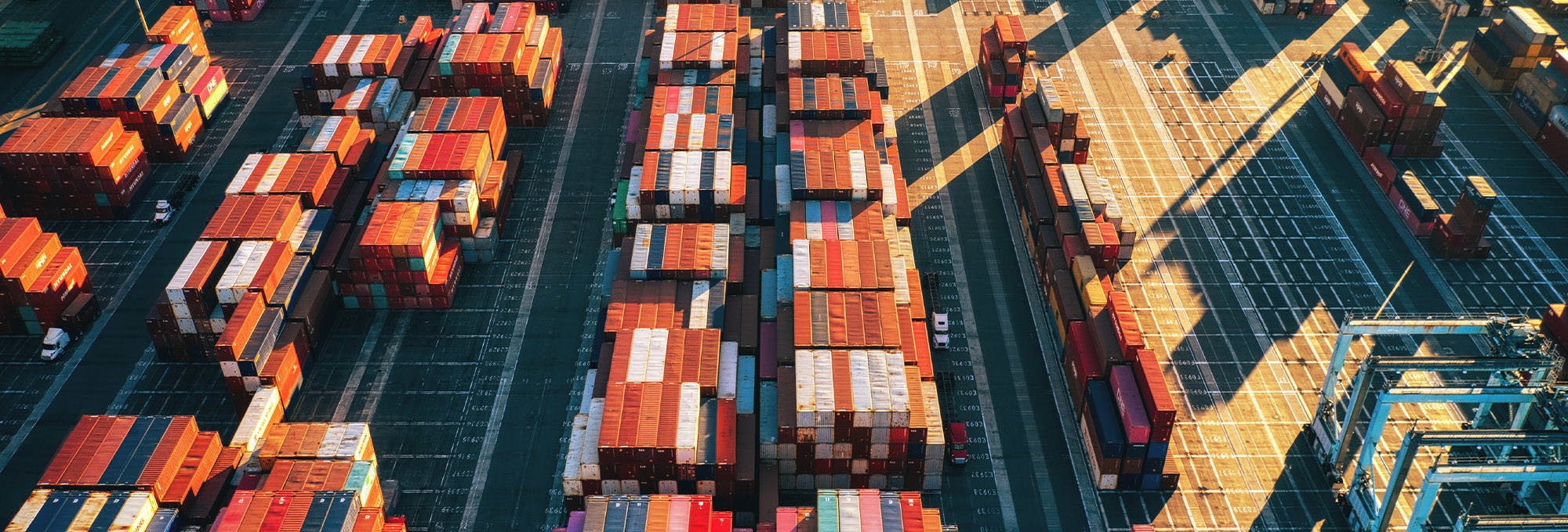 Overview of ship container yard with stacked containers. This helps represent the three economic questions 