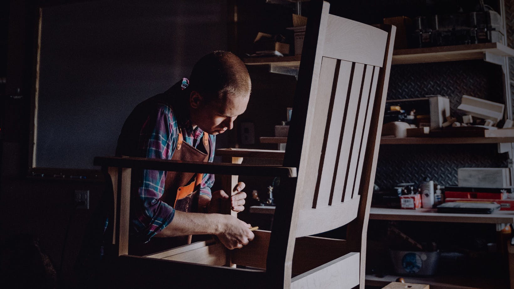 A carpenter assembles a chair in a workshop