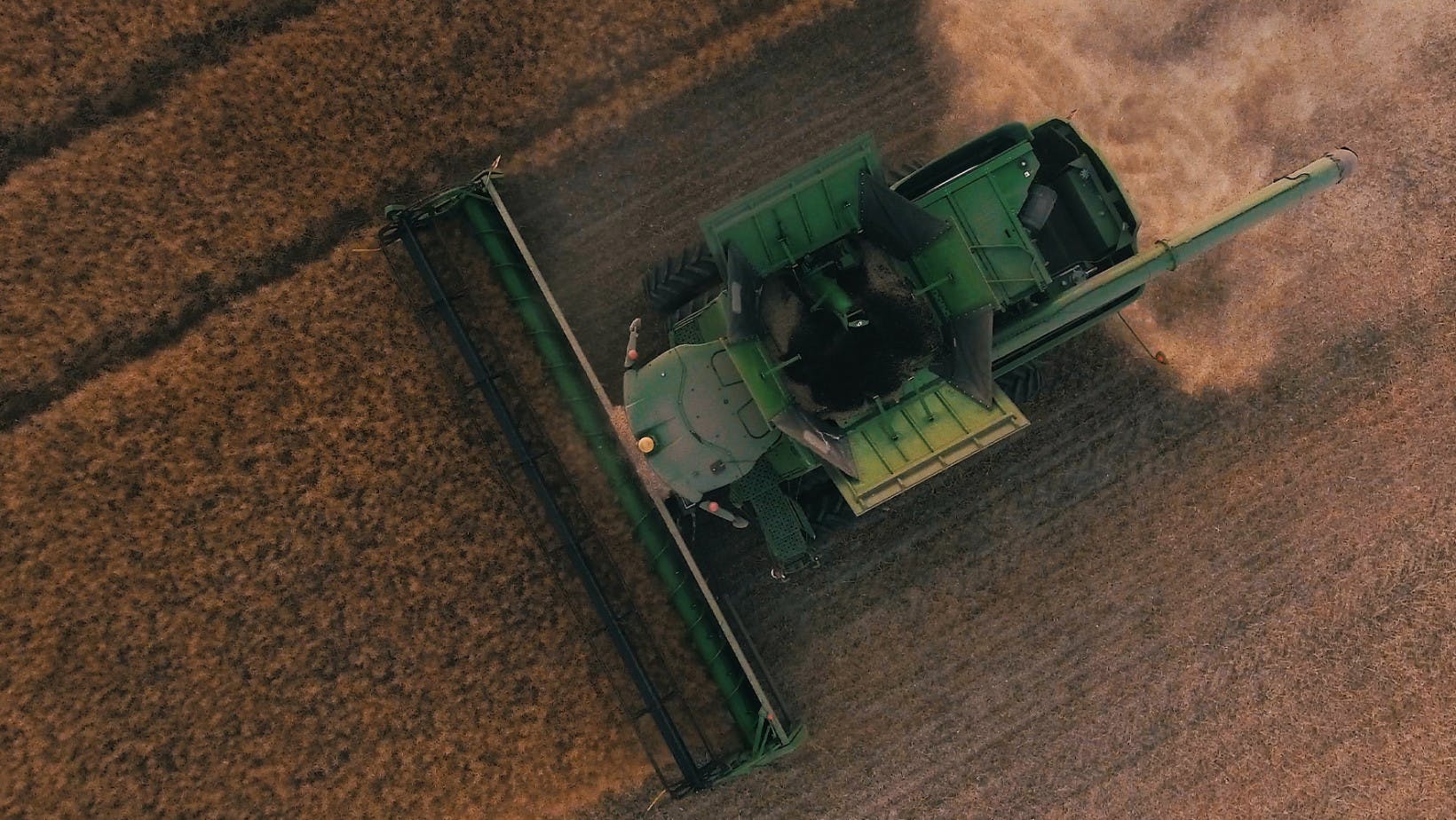 Overhead view of a green tracker working a field. This helps represent a perfectly competitive firm.