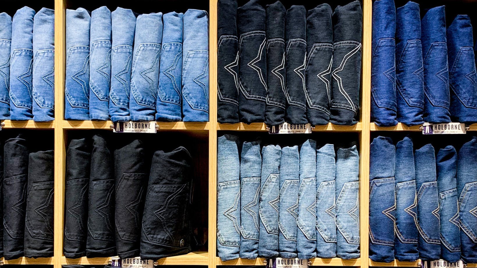 Stacks of different blue jeans in a shelf representing the topic elasticity of demand 